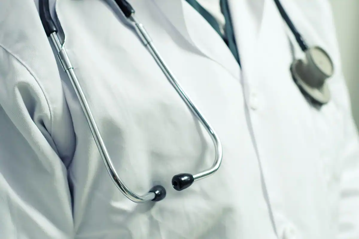 Halat alb de medic cu stetoscopul atârnat la gât, văzut din apropiere