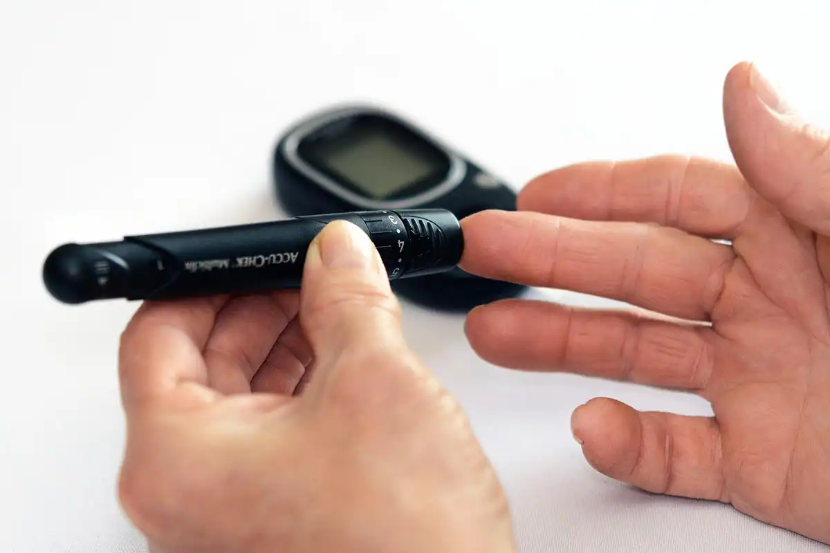 Vârstnic își măsoară glicemia acasă, cu glucometru și bandelete, pentru automonitorizarea diabetului